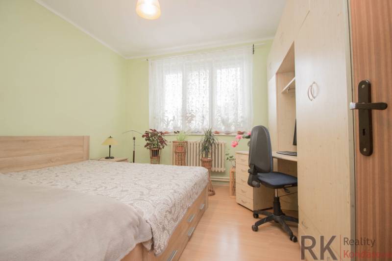 Hálószoba családi házban fa dekor padlóval, ággyal és íróasztallal.
