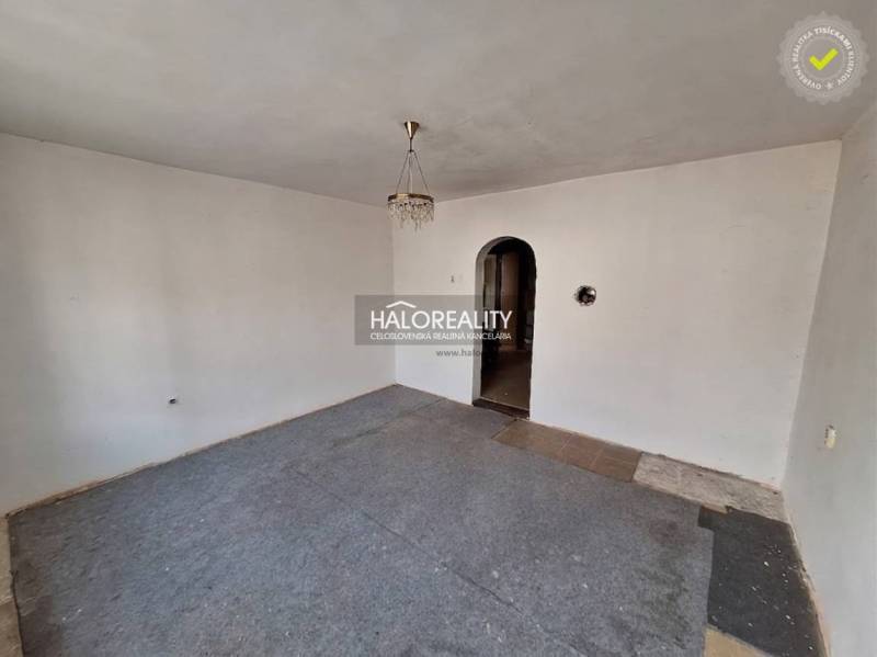 Egy szoba belseje fehér falakkal, szőnyeggel és csillárral, ingatlan - lakóhely.