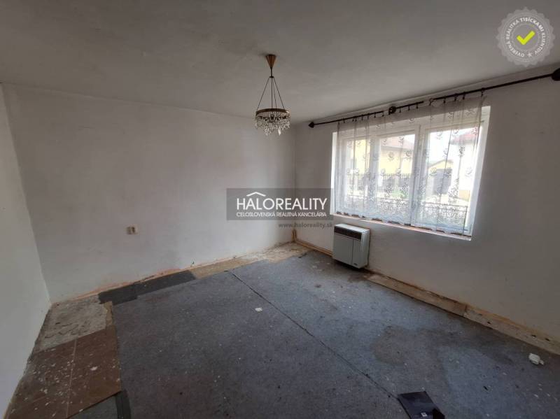 Szoba szőnyeggel, fehér falakkal és nagy ablakkal, felújításra alkalmas; Lakóingatlanok.