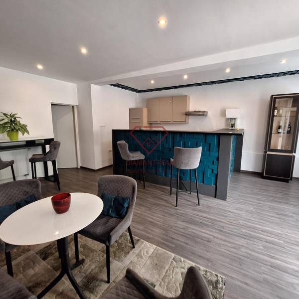 Családi ház belső tere bárpulttal, étkezőasztallal és kényelmes székekkel.