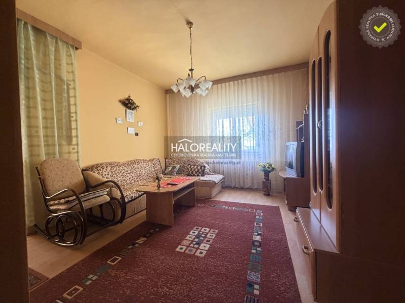 Nappali egy családi házban kényelmes kanapéval és fa dekorációjú padlóval.