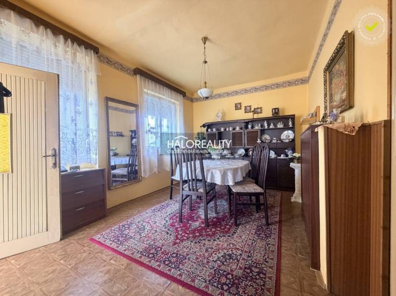 Ebédlő egy családi házban, fa dekorációjú padlóval, díszített szőnyeggel és asztallal.