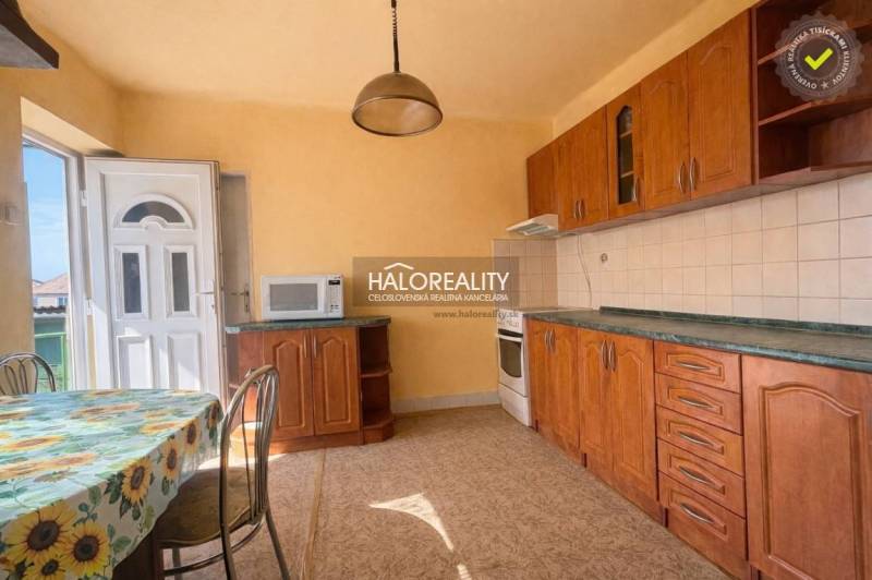 Családi ház konyhája fa dekorációval és napos fali dekorációval.