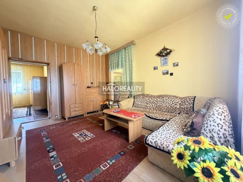 Nappali egy családi házban, fa dekorációjú padlóval és virágokkal.