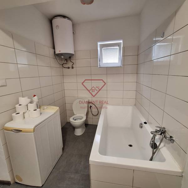 Fürdőszoba családi házban káddal, mosógéppel, bojlerrel és WC-vel.