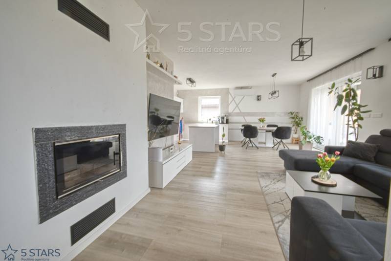 Nappali kandallóval, TV-vel és fa dekorációjú padlóval egy családi házban.