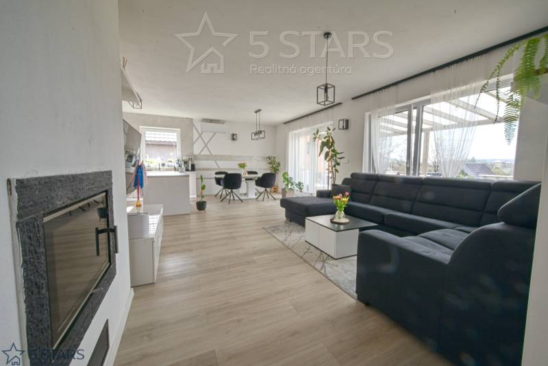 Nappali egy családi házban nagy kanapéval és fa dekorációjú padlóval.