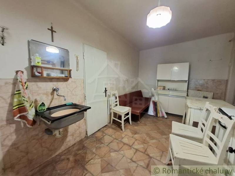 Családi ház belső tere csempézett fallal, bútorokkal és mosogatóval.