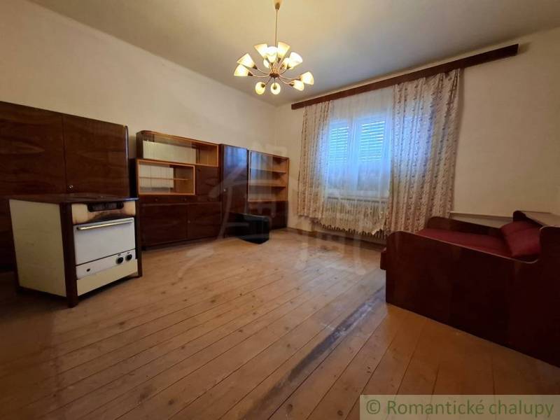 Nappali egy családi házban fa dekorációval, függönyökkel és kanapéval.