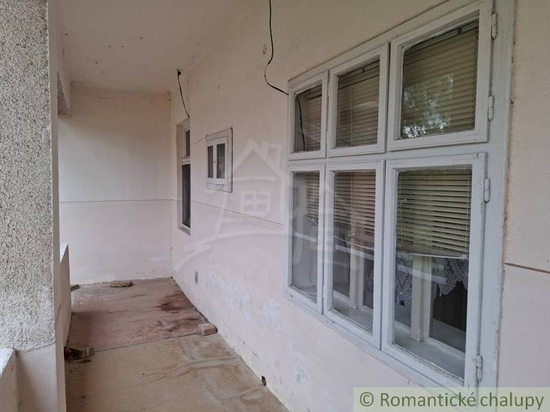 Családi ház Muzslán átjárható terasszal, redőnyös ablakokkal és betonpadlóval.