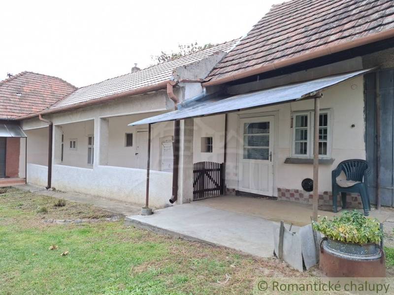 Régi házikó Mužlában terasszal és fa tetővel.