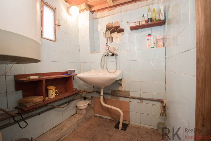 Fürdőszoba mosdóval, polcokkal és világítással, alkalmas rekreációs telkekre.