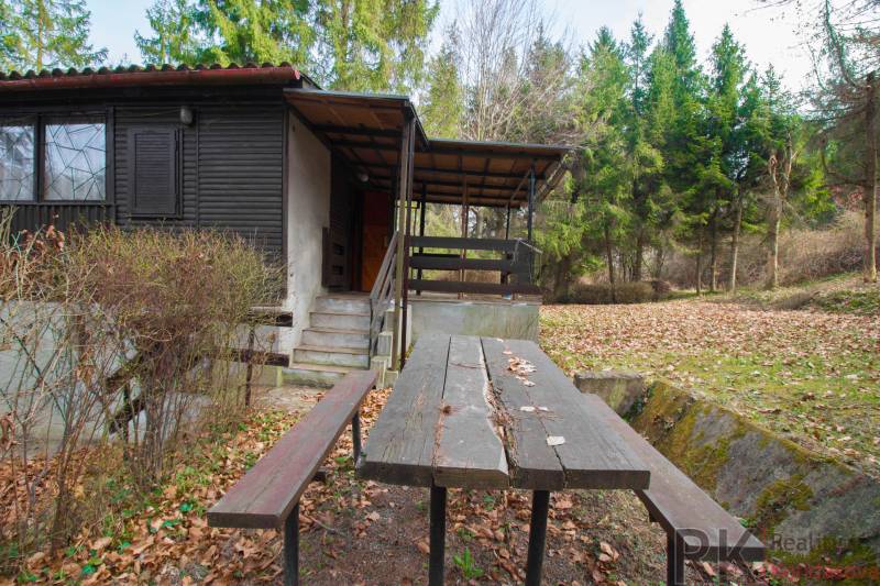 Nyaraló terasszal és asztallal a Holčíkovce-i üdülőterületen, erdővel körülvéve.