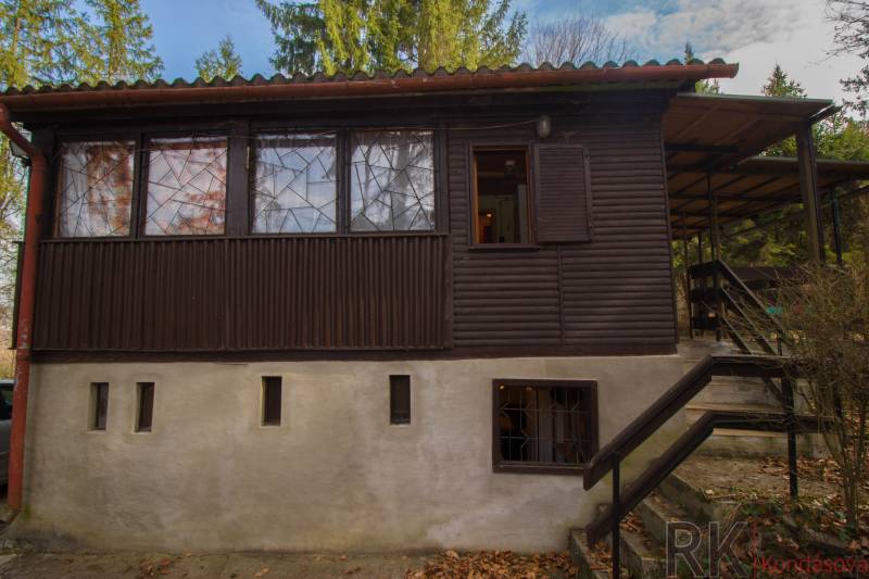 Faház a holčíkovcei üdülőterületen, zölddel és fákkal körülvéve.