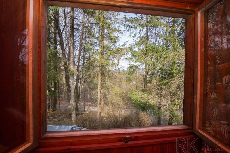 Kilátás az ablakból az erdőkre a Holčíkovce-i üdülőterületeken.