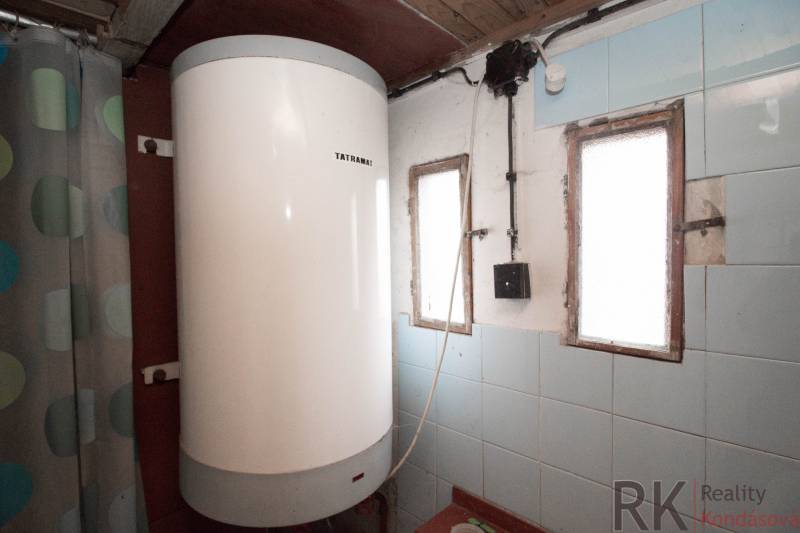 Bojler a kék csempékkel burkolt belső térben, üdülőterületen.