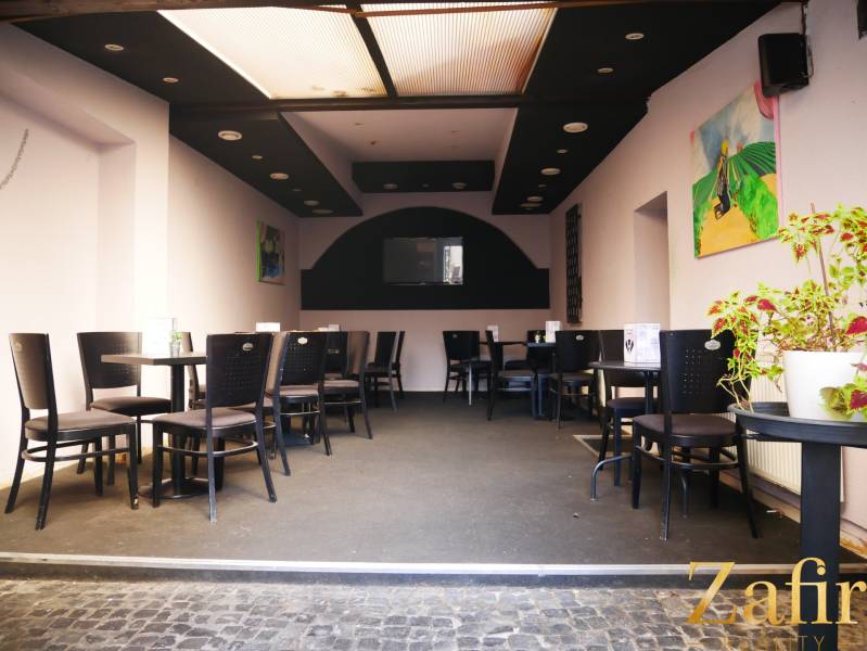 Belső vendéglátó terek ülőhelyekkel, dekorációkkal és szobanövénnyel.