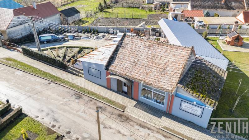 Kereskedelmi helyiségek Ekecsen hagyományos tetővel, járdával és kerttel.