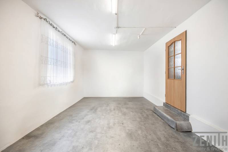 Fehér falak, beton padló, faajtó és függöny az üzlethelyiségben.