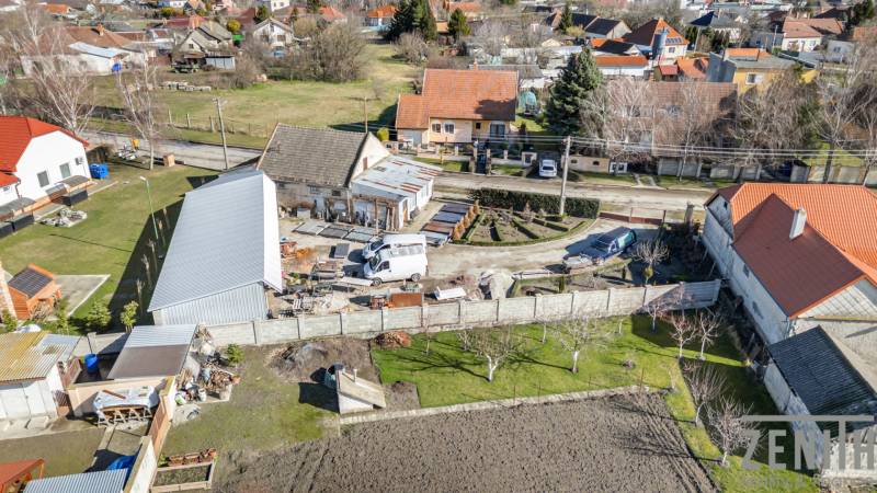 Kereskedelmi helyiségek Okočban, csendes vidéki környezetben lévő házakkal.