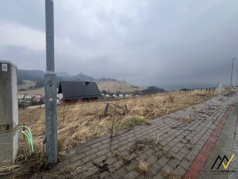 Kilátás a telkekre - lakóhely Ólublón, látható ösvénnyel és házzal.