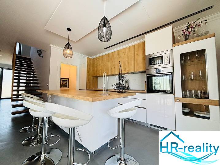 Modern konyha szigettel és bárszékekkel a villában.