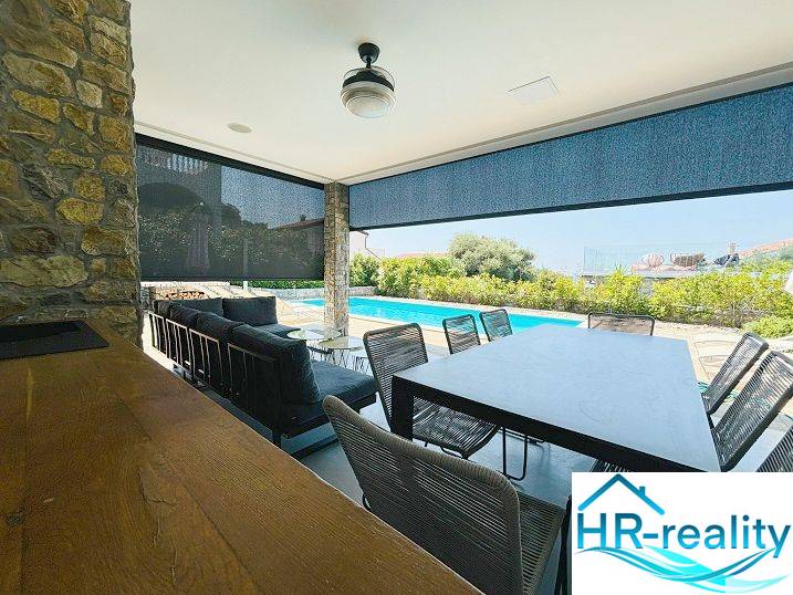 A jakisnicai villa terasza ülőhellyel és kilátással a medencére.