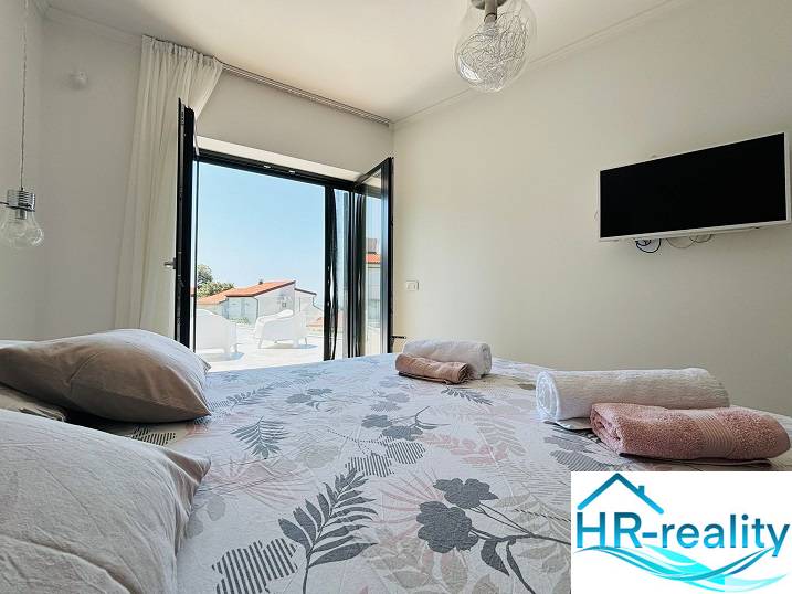 Hálószoba villában kilátással, ággyal és televízióval, ideális pihenésre.