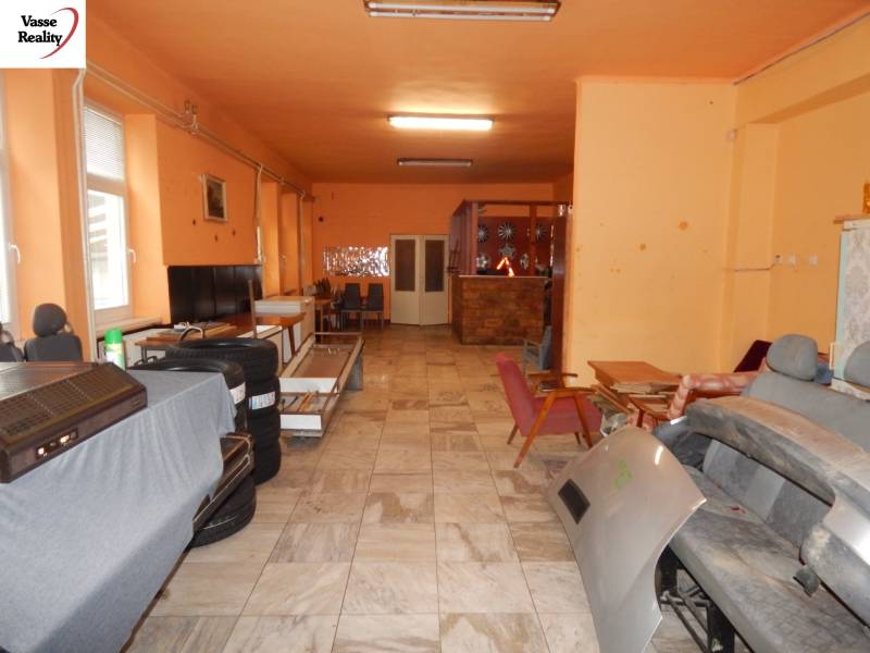 Vendéglátóipari helyiségek belső tere narancssárga falakkal, raktárhelyiség székekkel és felszereléssel.