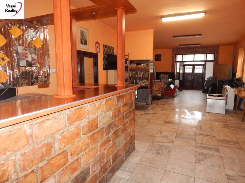 Étkező belső tér asztallal és könyvespolcokkal.