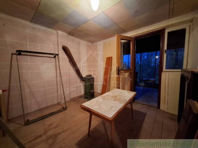 Egy fahatású padlóval és régi bútorokkal berendezett házikó belseje.