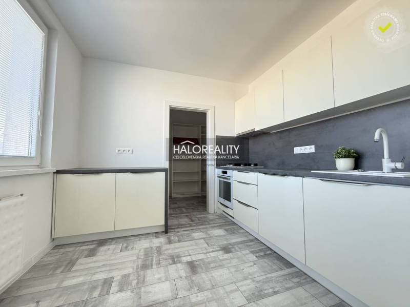 Konyha a kétszobás lakásban fa dekor padlóval és világos bútorokkal.