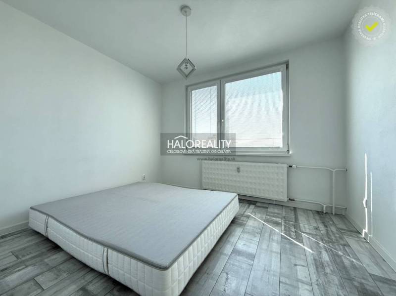 Hálószoba szürke, fa mintázatú padlóval egy kétszobás lakásban.