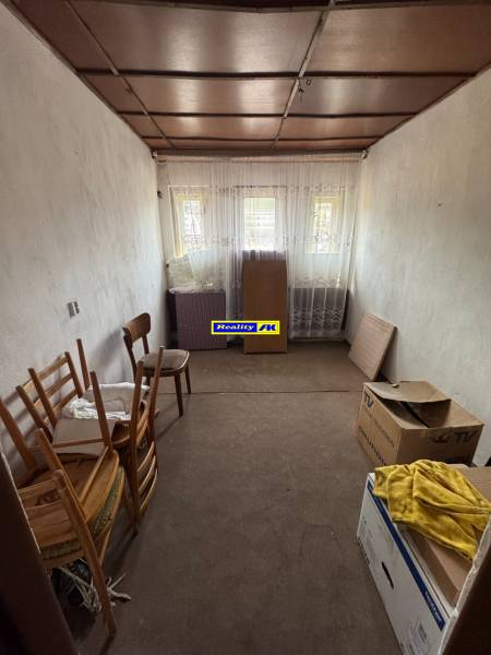 Egyszerű szoba kartondobozokkal és fa székekkel egy családi házban.