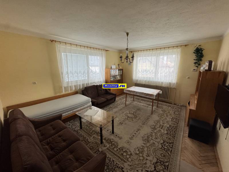 Nappali klasszikus berendezéssel, szőnyeggel és kanapéval egy családi házban.