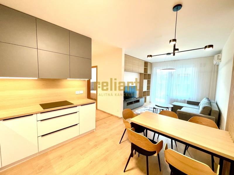 Konyha és nappali egy kétszobás lakásban, fa mintázatú padlóval és modern bútorokkal.