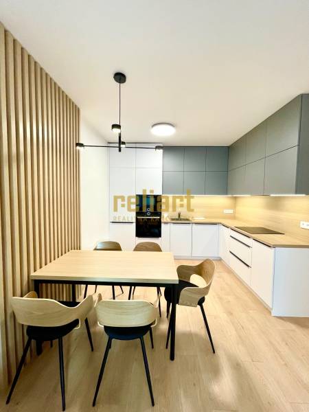 Konyha egy kétszobás lakásban fa dekoros padlóval és étkezőasztallal.