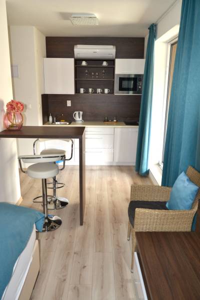 Konyha kétszobás lakásban bárpulttal és fa dekorációjú padlóval.