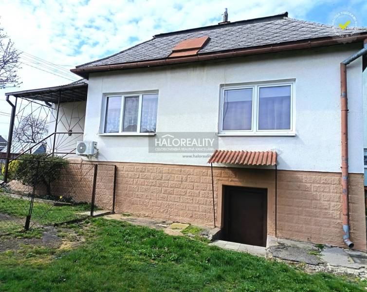Családi ház Hráňban füves udvarral, ablakokkal és bejárati ajtóval.