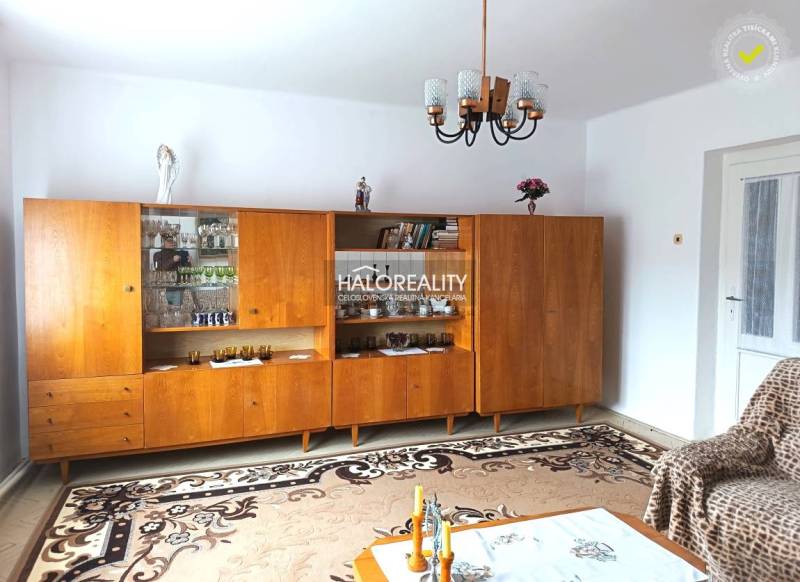 Nappali egy családi házban, fa nappali szekrénnyel és csillárral.