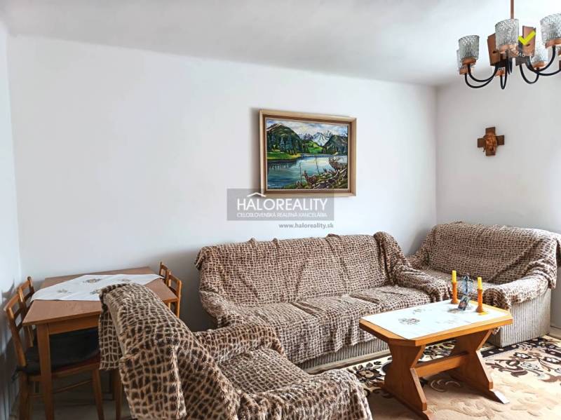 Nappali egy családi házban kanapékkal és egy képpel a falon.