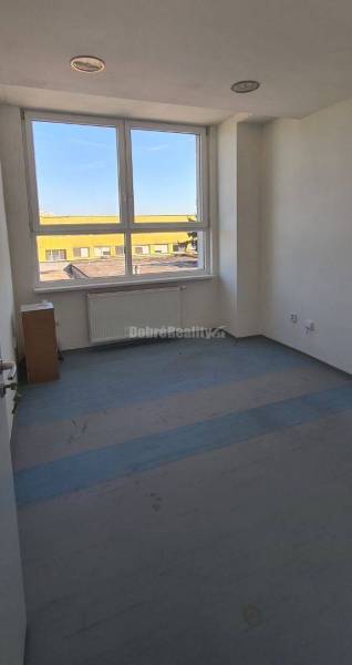 Prázd iroda nagy ablakkal, fehér falakkal és fa dekorációjú padlóval.