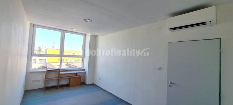 Iroda belső tér fehér falakkal, kék padlóval és nagy ablakkal.