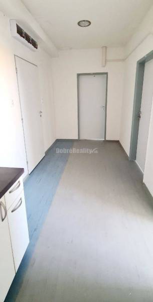 Iroda folyosó világos falakkal, ajtókkal és fa dekorációjú padlóval.