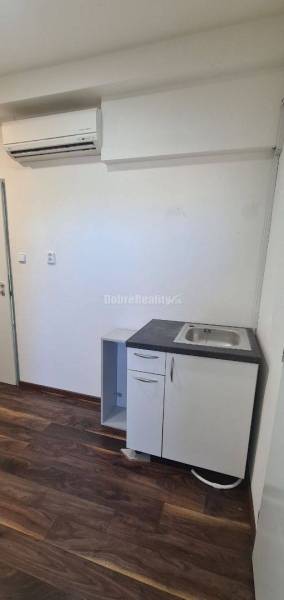 Iroda légkondicionálóval, mosdóval és fa dekorációjú padlóval.