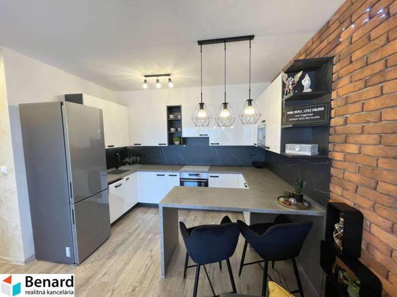 Konyha egy kétszobás lakásban, fa dekor padlóval és téglafal burkolattal.