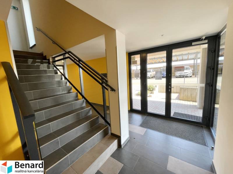 Lépcsőház sötét csempékkel és üvegezett ajtókkal Kassán, a Borievkova utcában.