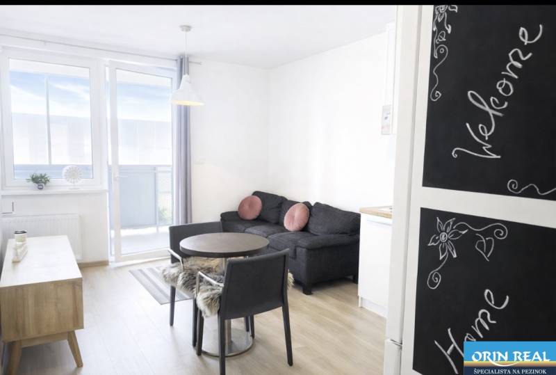 Nappali egy kétszobás lakásban fa dekor padlóval és erkéllyel.