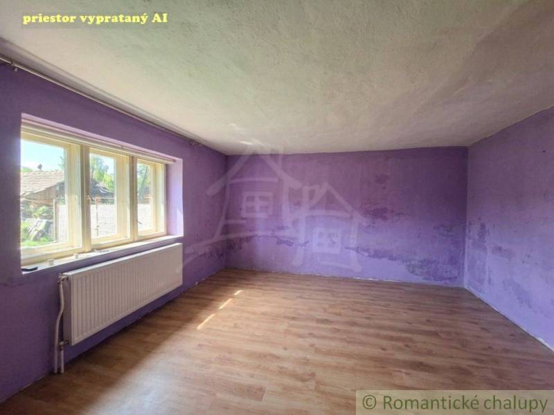 Üres szoba lila falakkal egy családi házban, fa dekorációjú padlóval.