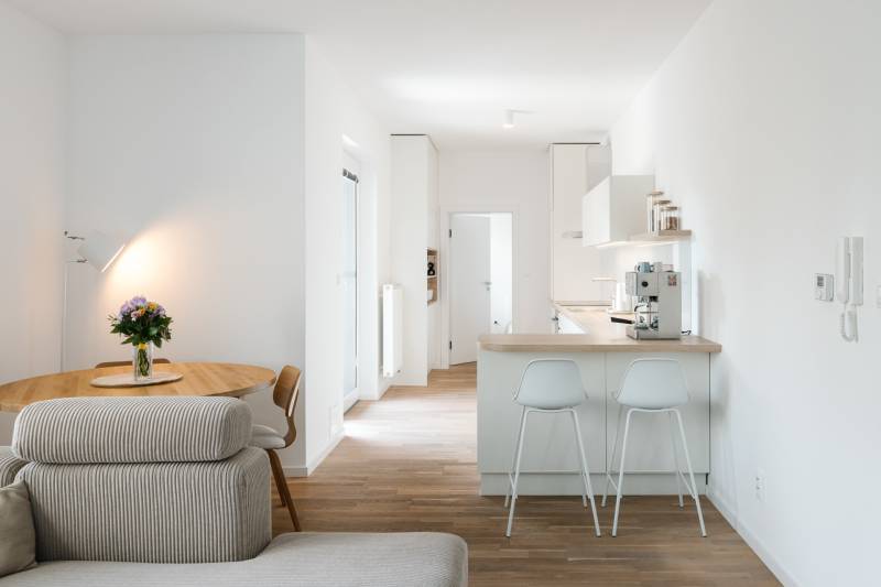 Konyha asztallal, kanapéval és fa dekorációjú padlóval egy 4 szobás lakásban.